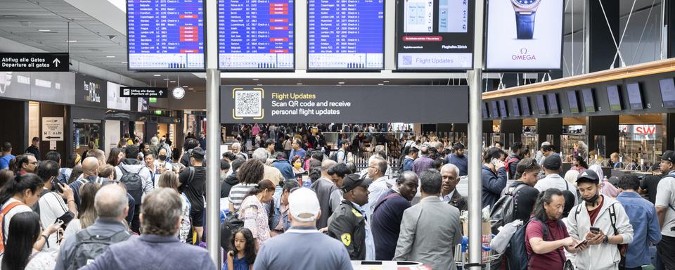 Des passagers attendant leur vol à l'aéroport de Genève. [Keystone - Ennio Leanza]