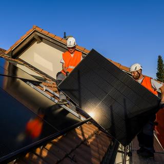 Couvrir son toit de panneaux solaires, un investissement de moins en moins reluisant en Suisse. [Keystone - Jean-Christophe Bott]