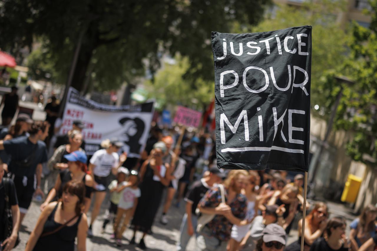 Des personnes manifestent contre les violences policières et en mémoire de Mike Ben Peter, à la suite de l'aquittement en appel de six policiers lausannois, le 13 juillet 2024 à Lausanne. [KEYSTONE - VALENTIN FLAURAUD]