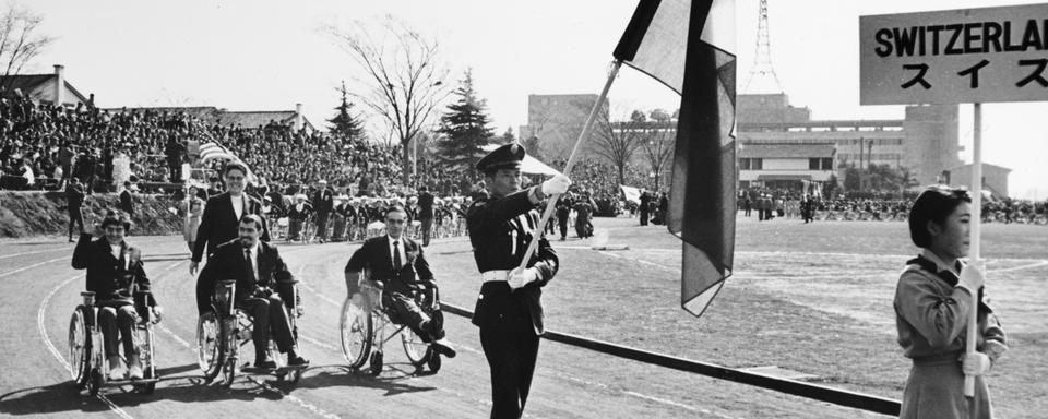 La délégation des athlètes suisse à l'ouverture des Jeux paralympiques de Tokyo en 1964. [Keystone - Str]