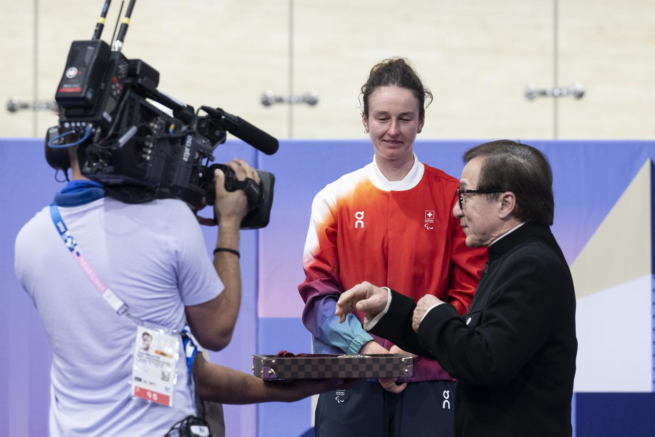 Rigling a reçu la médaille des mains de l'acteur Jackie Chan, qui a assuré la veille l'un des relais de la flamme. [KEYSTONE - ENNIO LEANZA]