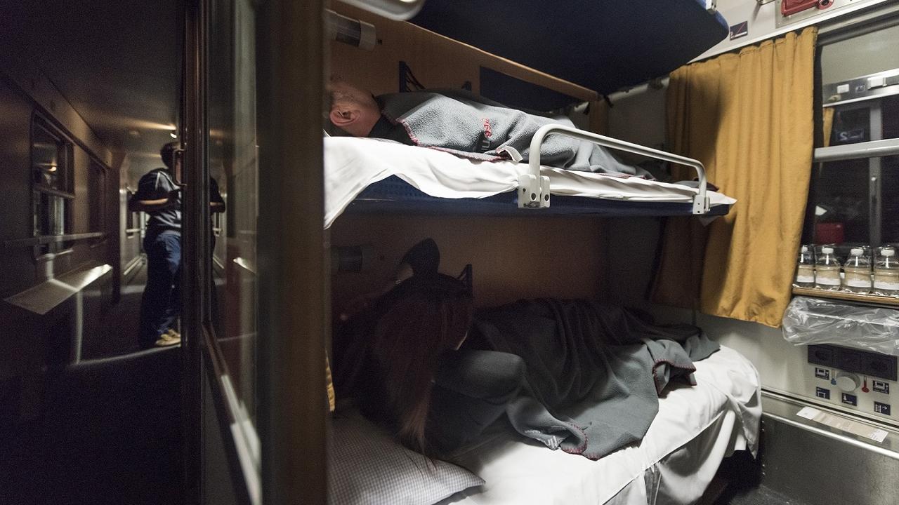 Des passagers dans un train de nuit. [Keystone - Christian Beutler]