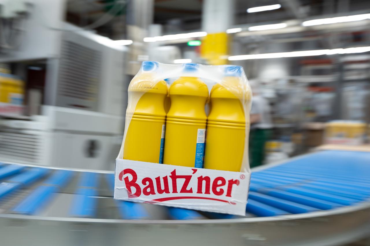 Des bouteilles de moutarde Bautz'ner roulent sur un tapis roulant sur une chaîne de remplissage de la Bautz'ner Senf und Feinkost GmbH. [KEYSTONE - SEBASTIAN KAHNERT]