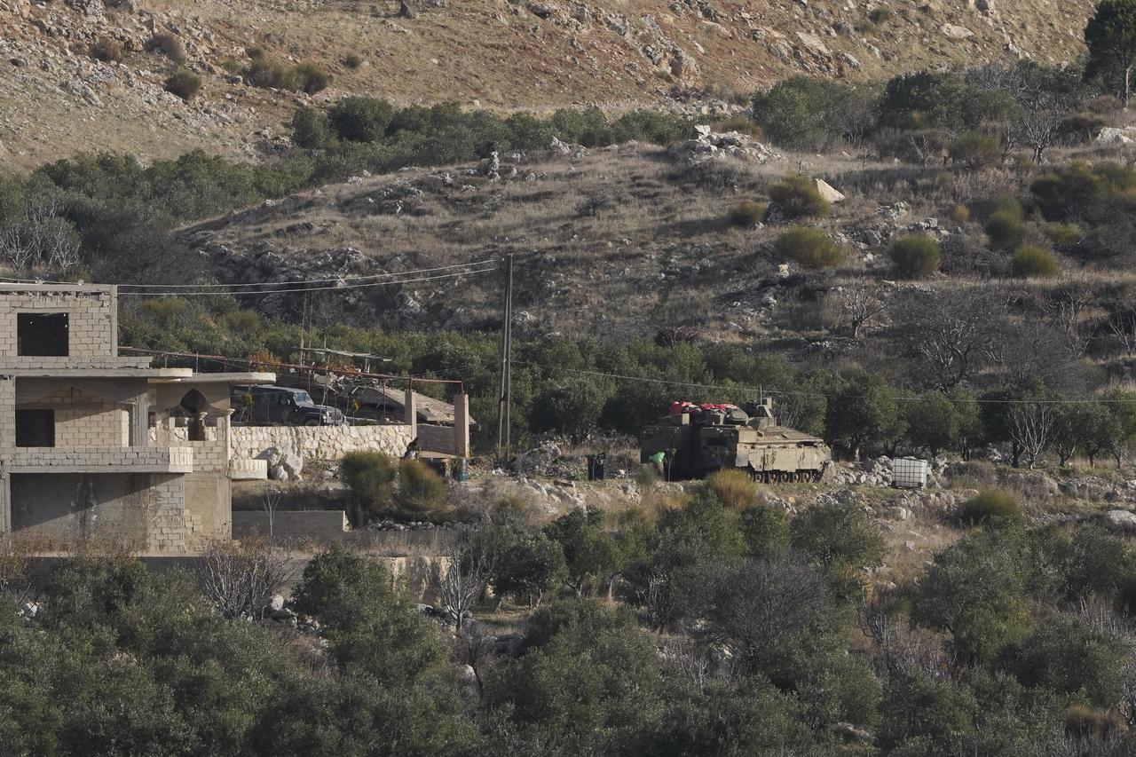 Des véhicules blindés israéliens stationnent à l'intérieur de la zone tampon près de la ligne Alpha qui sépare le plateau du Golan contrôlé par Israël de la Syrie, dans la ville de Majdal Shams, mardi 17 décembre 2024. [KEYSTONE - MATIAS DELACROIX]