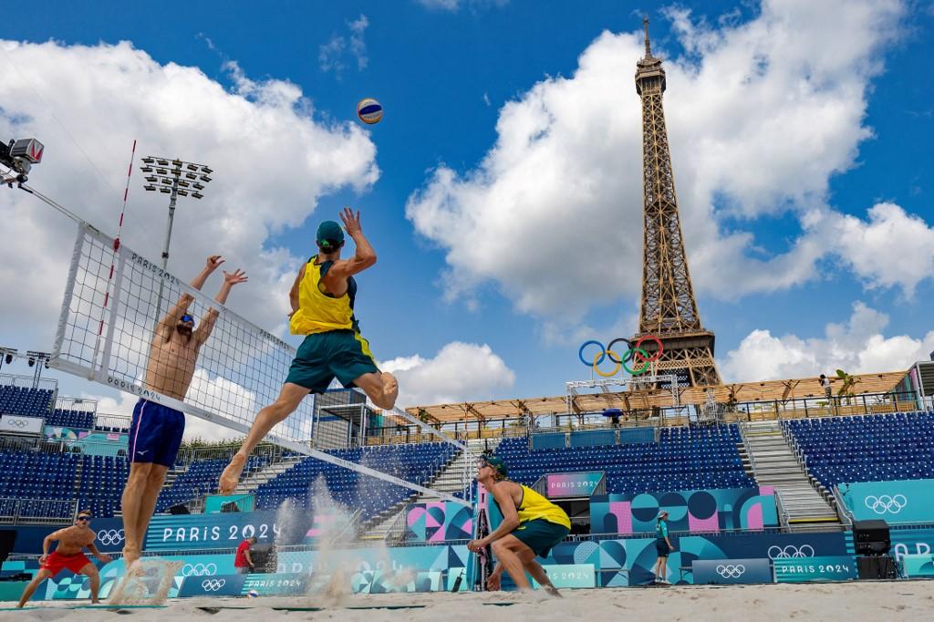 Jogadores noruegueses de vôlei de praia participam de um treino antes da abertura dos Jogos Olímpicos de Paris 2024, no estádio da Torre Eiffel. [AFP - ODD ANDERSEN]