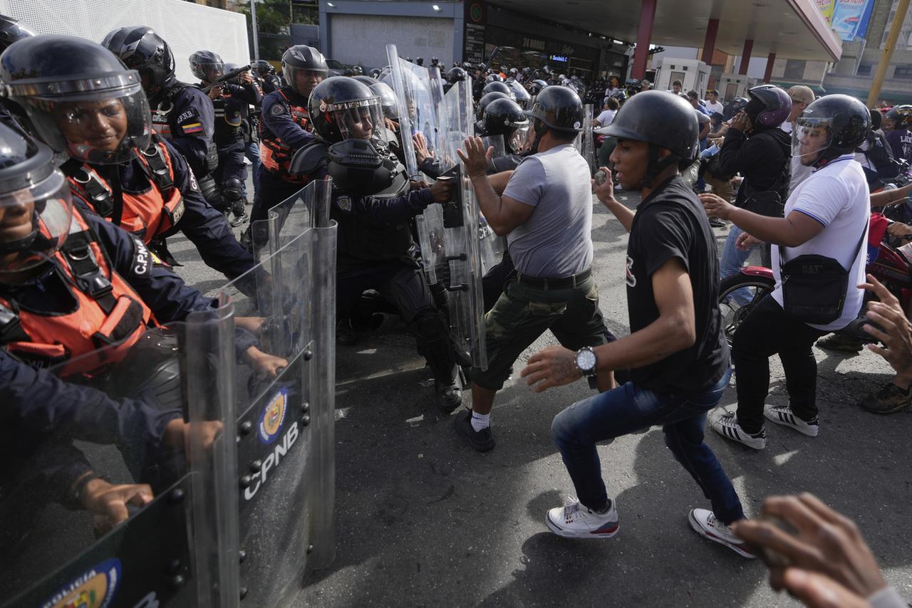 Manifestantes atacam a polícia durante manifestações contra os resultados oficiais das eleições, um dia após as autoridades eleitorais declararem o presidente Nicolás Maduro vitorioso em Caracas, Venezuela, segunda-feira, 29 de julho de 2024. (Foto AP/Fernando Vergara) [Keystone - Fernando Vergara]