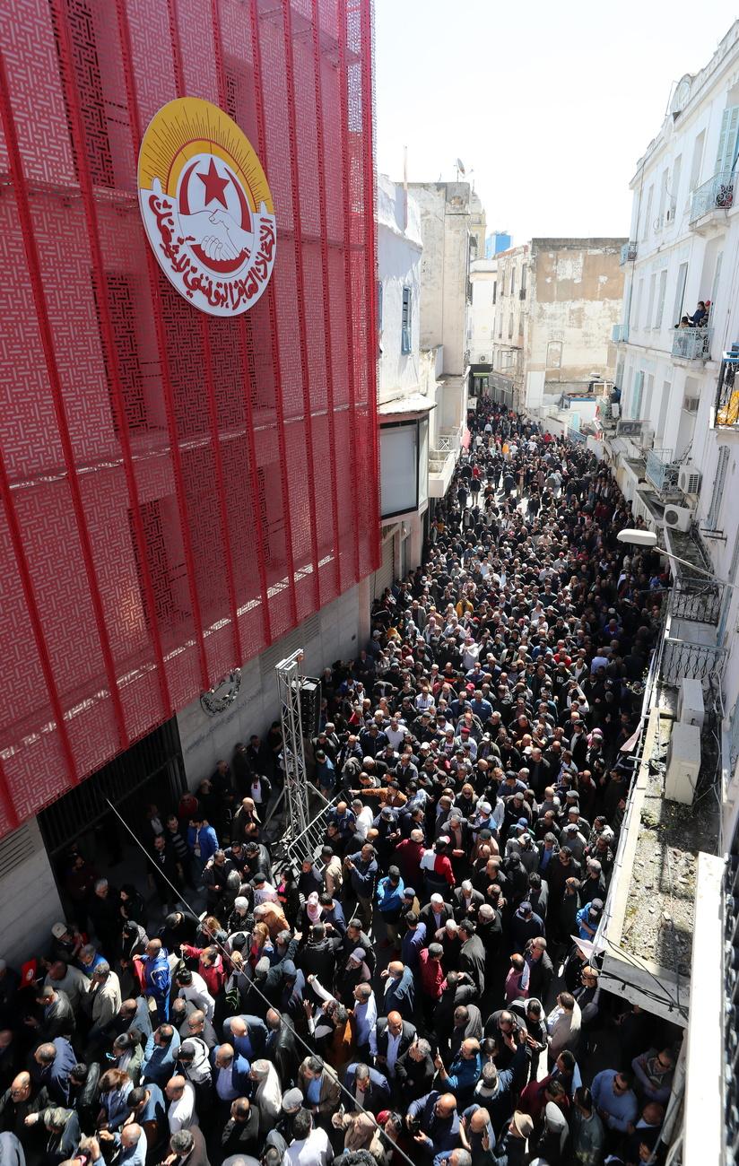 Des membres de la UGTT en attendant le début de la manifestation pour le 1er Mai à Tunis. [KEYSTONE - MOHAMED MESSARA]