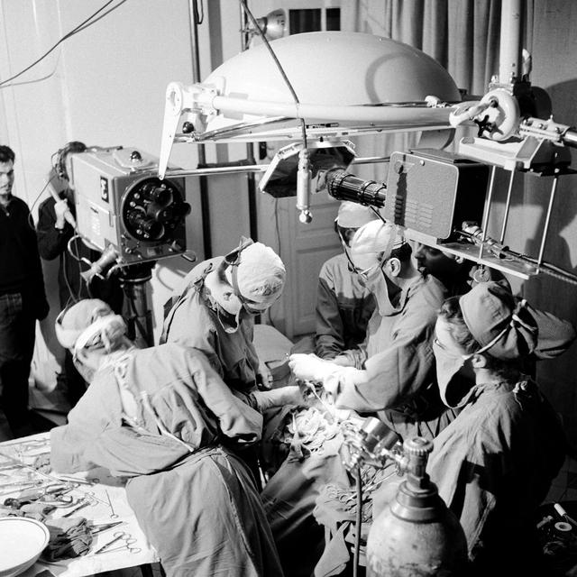 Dans une salle d'opération, tournage d'une greffe sur un nerf pour "Les Entretiens de Bichat", la semaine de formation médicale continue annuelle en France (1957). [AFP - Daniel Fallot / Ina]