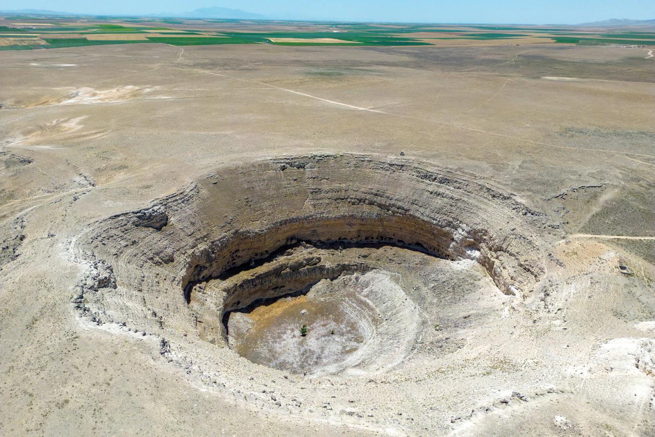 Cette photographie aérienne montre une vue du gouffre asséché de Cirali à Karapinar dans la province de Konya en Anatolie centrale, le 24 juin 2024. [AFP - YASIN AKGUL]