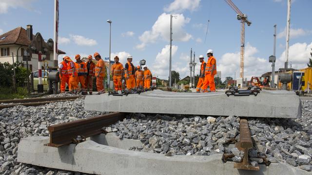 Des ouvriers sur un chantier de gare dans le canton de Fribourg (image d'illustration). [Keystone - Jean-Christophe Bott]
