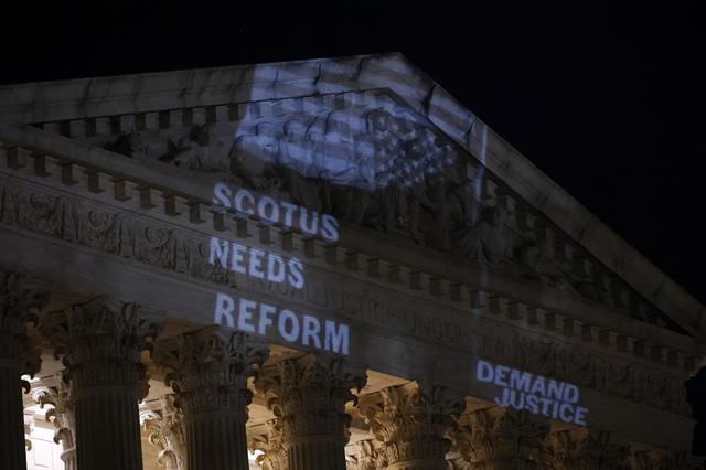 Le drapeau américain renversé est projeté sur la Cour suprême des États-Unis à Washington pour dénoncer la partialité des juges et demander une réforme de l'instance juridique. [Getty Images via AFP - PAUL MORIGI]