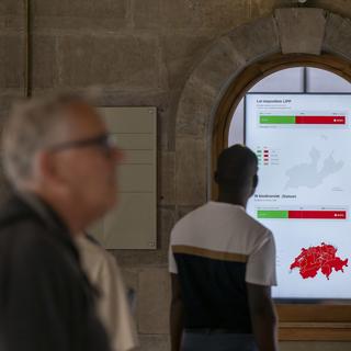 Une personne regarde le résultat des votations fédérales le 22 septembre 2024 à Genève. [Keystone - Martial Trezzini]