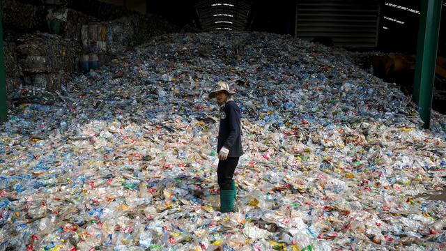 Un travailleur immigré dans une usine de recyclage des bouteilles en plastique, Thaïlande. [Keystone/EPA - Diego Azubel]