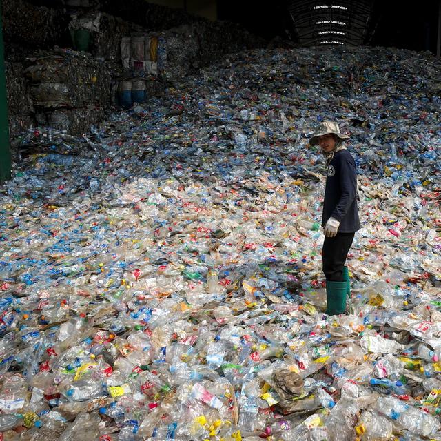 Un travailleur immigré dans une usine de recyclage des bouteilles en plastique, Thaïlande. [Keystone/EPA - Diego Azubel]