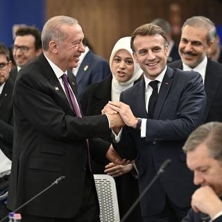 Emmanuel Macron et Recep Tayyip Erdogan se serrent la main au sommet de la Communauté politique européenne. [AP Photo / Keystone - Denes Erdos]