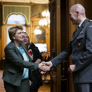 La ministre de la Défense Viola Amherd serre la main du chef de l'armée Thomas Süssli en marge du débat au National. [Keystone - Anthony Anex]