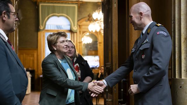 La ministre de la Défense Viola Amherd serre la main du chef de l'armée Thomas Süssli en marge du débat au National. [Keystone - Anthony Anex]