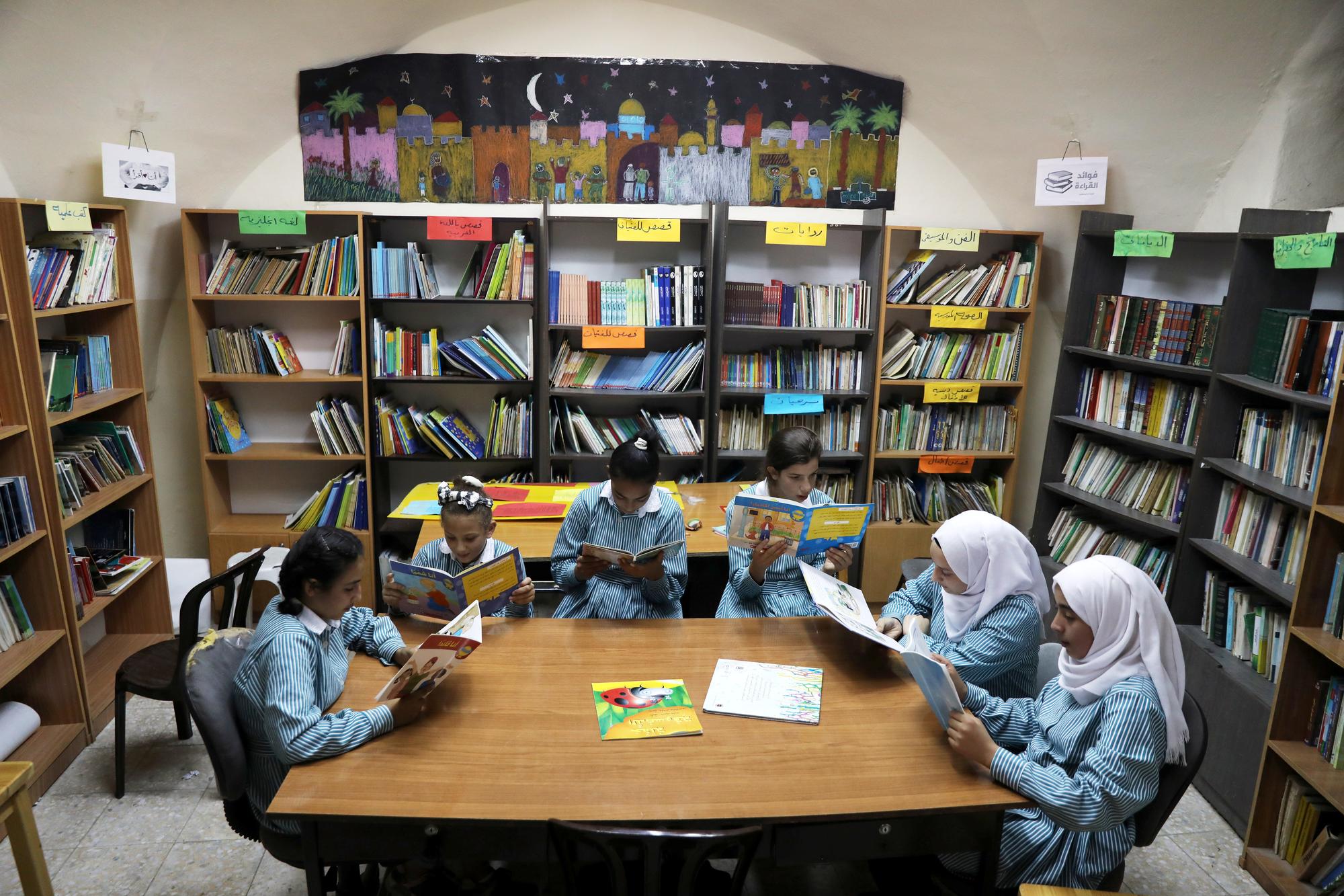 Des écolières palestiniennes lisent dans la bibliothèque d'une école gérée par l'Unrwa, à Jérusalem-Est, le 10 octobre 2018. [Reuters - Ammar Awad]