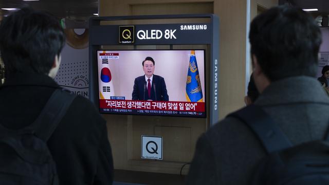 Des personnes regardent la retransmission en direct du président sud-coréen Yoon Suk Yeol s'adressant à la nation, dans une station de Séoul, en Corée du Sud, le 12 décembre 2024. [Keystone - JEON HEON-KYUN]