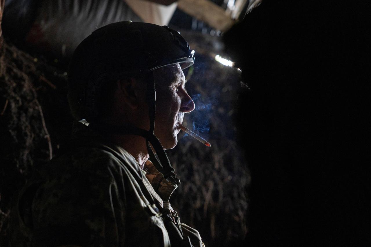 Un militaire ukrainien de la 22e brigade mécanisée séparée fume une cigarette à l'entrée d'un abri sur une position d'artillerie, dansla périphérie de Tchassiv Yar, le 19 avril 2024. [REUTERS - Thomas Peter]