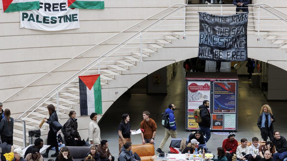 Deux femmes et un homme ont arrachés près de 25 drapeaux palestiniens installés par le collectif estudiantin à Uni-Mail. [Keystone - Salvatore Di Nolfi]
