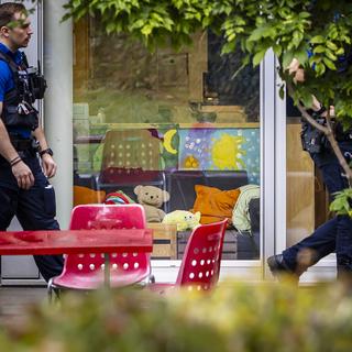 Des policiers à Oerlikon, Zurich, après l'attaque au couteau d'un groupe d'enfants. [Keystone - Michael Buholzer]