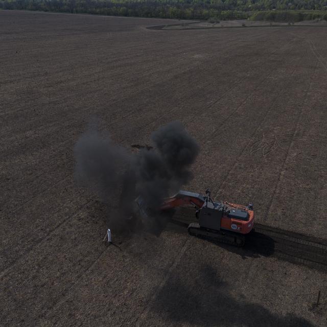 Une démineuse en action dans un champ en Ukraine. [Keystone - Bernat Armangue]