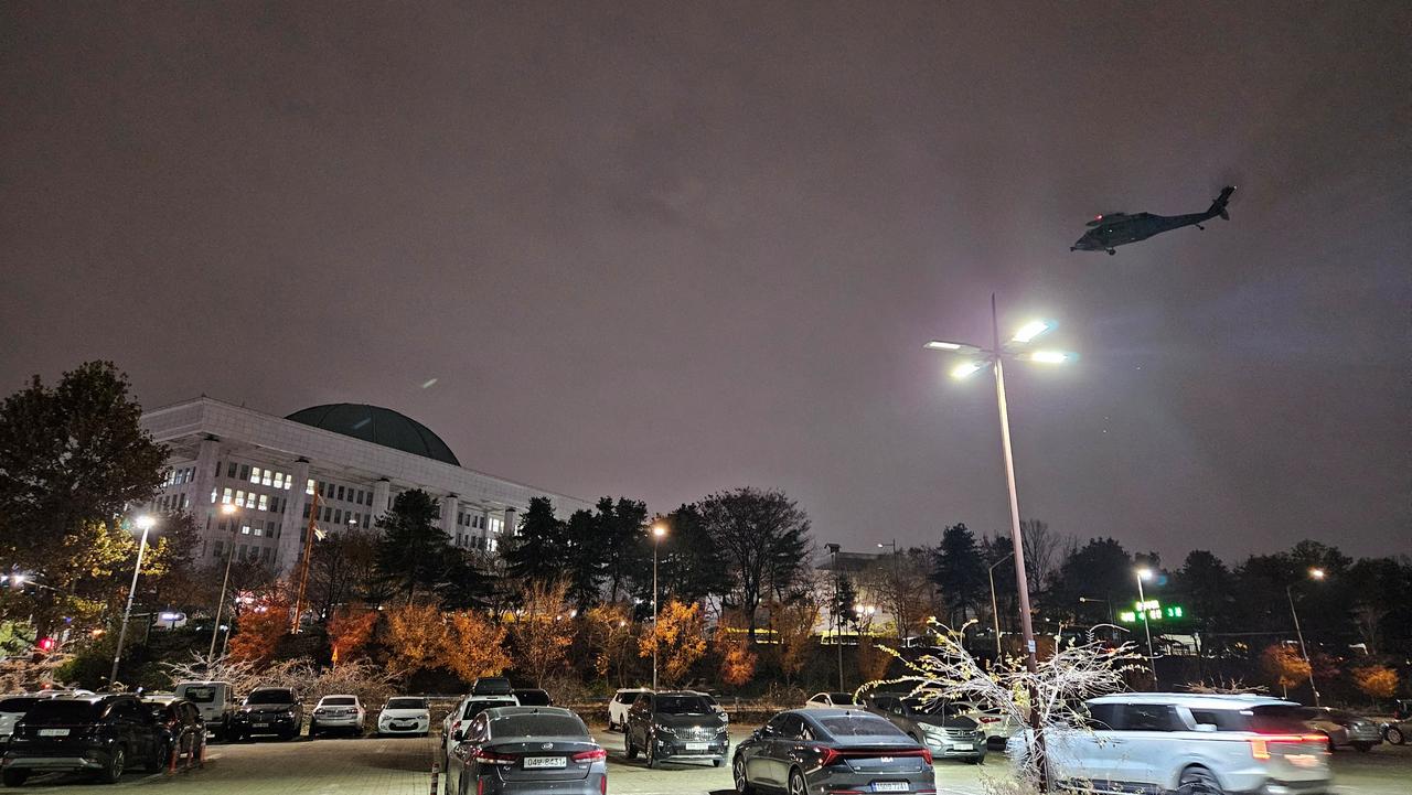 Des hélicoptères entourent l'Assemblée nationale sud-coréenne après l'annonce de la mise en place de la loi martiale mardi. [via REUTERS - YONHAP]