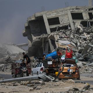 Des Palestiniens partent avec leurs biens après un ordre d'évacuation émis par l'armée israélienne, à Khan Younès, dans le sud de la bande de Gaza, le 2 juillet 2024. [Keystone - EPA/MOHAMMED SABER]