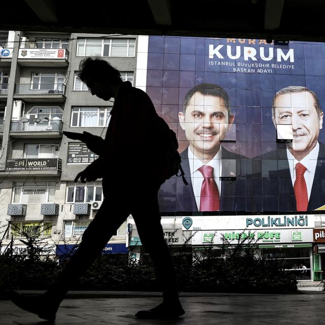 Une personne devant des affiches du parti d'Erdogan. [Keystone/EPA - Erdem Sahin]