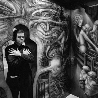 L'artiste grison Hans Ruedi Giger dans la silhouette découpée d'une de ses expositions. [Keystone - Photopress-Archiv/Str]