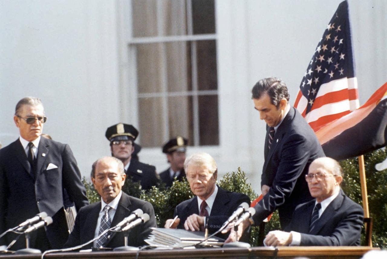 La signature de l'accord de Paix, le 26 mars 1979, entre le président égyptien Anouar el Sadat et le Premier ministre israélien Menachem Begin, à Camp David, la résidence secondaire des présidents des Etats-Unis. [KEYSTONE - STR]