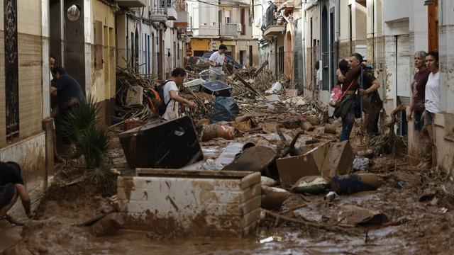 Des habitantes et habitants de la municipalité espagnole de Paiporta, près de Valence, constatent les dégâts dans leurs maisons, dévastées par les inondations meurtrières qui ont frappé la région. [KEYSTONE - BIEL ALINO]