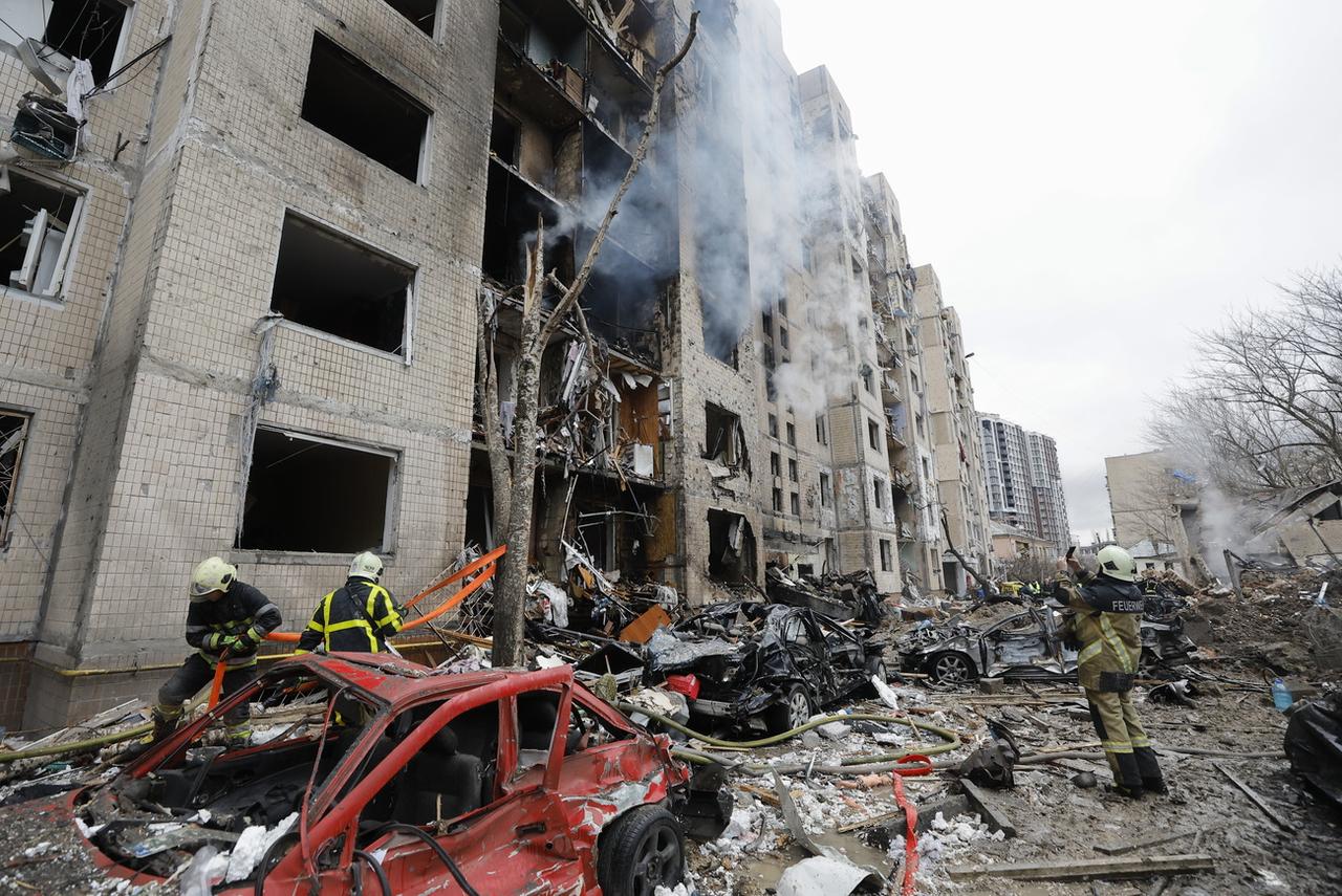 Des pompiers ukrainiens travaillent près d'un immeuble détruit par une frappe de missile à Kiev. [Keystone - Sergey Dolzhenko]