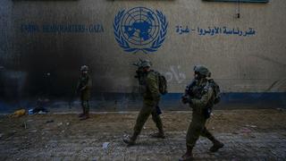 Des soldats israéliens prennent position alors qu'ils entrent dans le siège de l'UNRWA. [KEYSTONE - ARIEL SCHALIT]