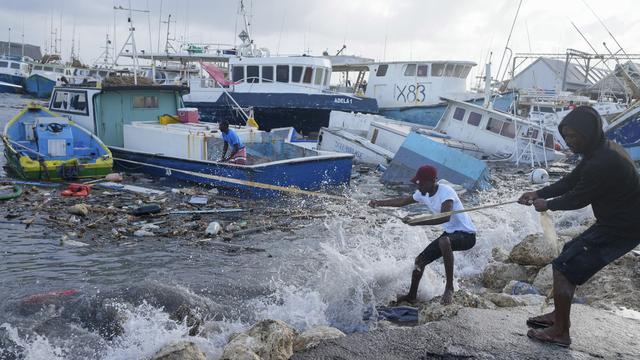 Les bateaux de pêche endommagés par l'ouragan Béryl sont renversés dans la pêcherie de Bridgetown à la Barbade, le lundi 1er juillet 2024. [KEYSTONE - RICARDO MAZALAN]