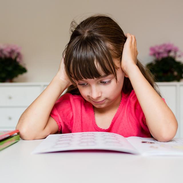 Une petite fille a du mal avec ses devoirs. [Depositphotos - Bigandt]