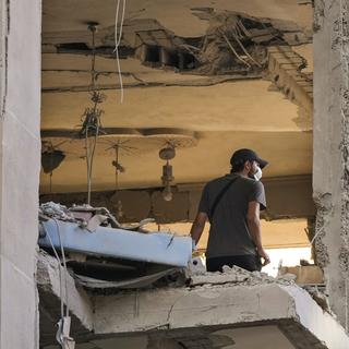 Un homme dans un immeuble touché par Israël au Liban. [Keystone/AP Photo - Hassan Ammar]