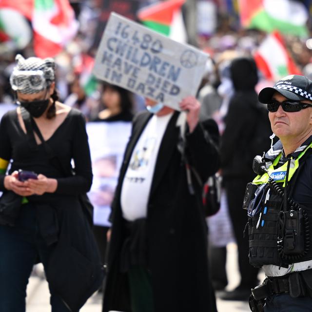 Un policier surveille une marche solidaire avec la Palestine. [Keystone/EPA - James Ross]