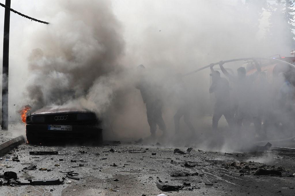 Des pompiers libanais éteignent le feu d'une voiture incendiée après une frappe israélienne dans la ville de Saïda, au sud du pays. Selon le Fatah et une source de sécurité libanaise, un chef de l'organisation palestinienne a été tué lors de cette attaque. [AFP - MAHMOUD ZAYYAT]