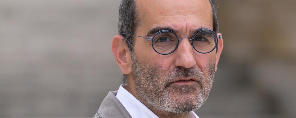 Le député français nouvellement élu pour le parti écologiste Pouria Amirshahi pose à son arrivée pour une journée d'accueil à l'Assemblée nationale à Paris, le 1er juillet 2024. [AFP - Bertrand Guay]