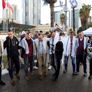 Des hommes rassemblés à Tel-Aviv pour prier pour la libération des otages israéliens, au 100e jour de la guerre entre Israël et le Hamas. [EPA/Keystone - Abir Sultan]