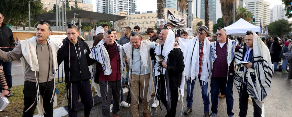 Des hommes rassemblés à Tel-Aviv pour prier pour la libération des otages israéliens, au 100e jour de la guerre entre Israël et le Hamas. [EPA/Keystone - Abir Sultan]