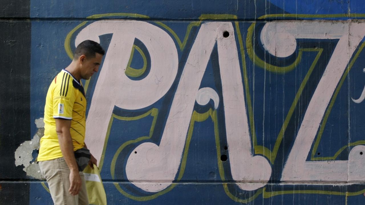 Un graffiti avec le mot "paix" sur un mur à Cali, en Colombie, au moment de la signature de l'annonce de l'accord historique de paix en 2016. [KEYSTONE - CHRISTIAN ESCOBAR MORA]