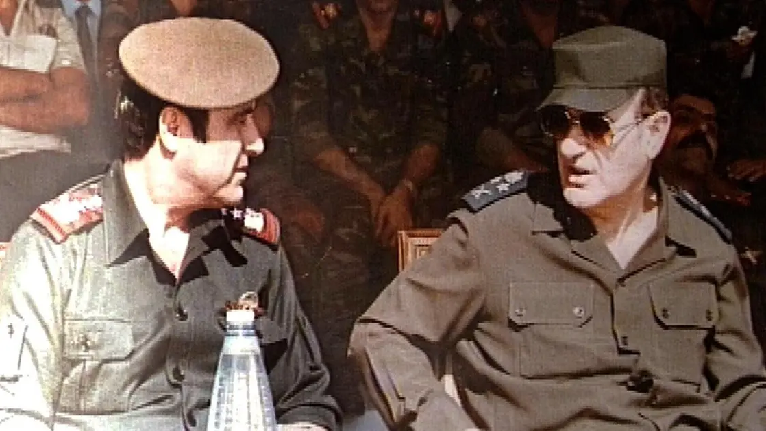 Hafez el-Assad avec son frère Rifaat lors d'une cérémonie militaire à Damas en 1984. [Domaine public]