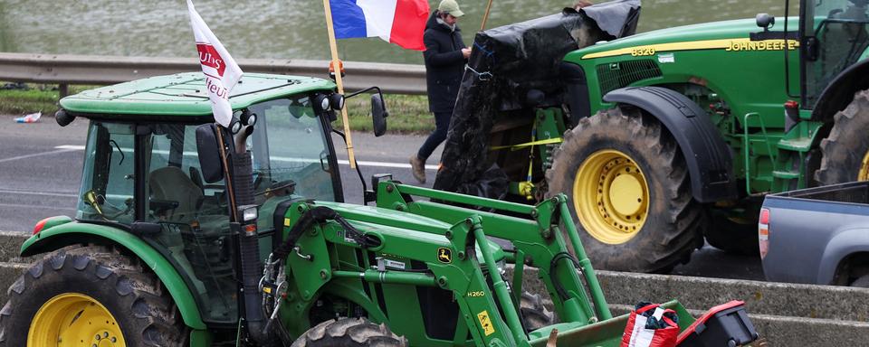 Des véhicules sont garés lors d'un blocus par des agriculteurs sur l'autoroute A4 pour protester contre les pressions sur les prix, les taxes ou encore la réglementation verte  à Jossigny, près de Paris, le 30 janvier 2024. [reuters - Yves Herman]