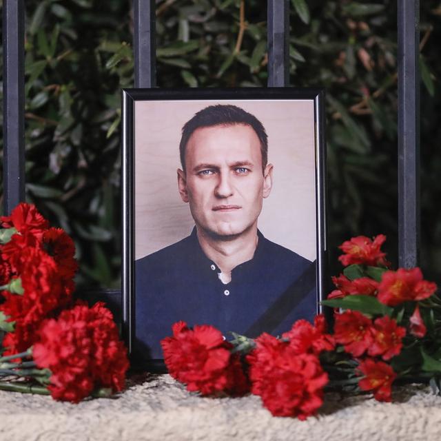 Des fleurs sont déposées près d'un portrait du défunt chef de l'opposition russe Alexeï Navalny devant l'ambassade de Russie, à Tbilissi, en Géorgie. [Keystone - EPA/DAVID MDZINARISHVILI]