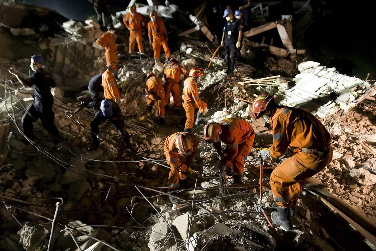 Des membres d'une équipe chinoise au travail dans les débris laissés par le tremblement de terre de 2010 en Haïti. [KEYSTONE - LOGAN ABASSI / UN PHOTO HANDOUT]
