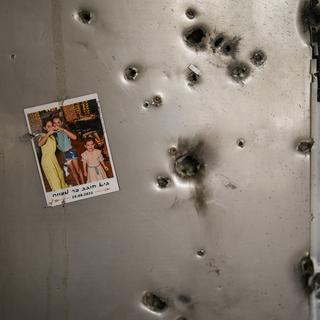 Une photo est accrochée à un réfrigérateur à côté d'impacts de balles dans une maison du kibboutz Kissufim, dans le sud d'Israël, le samedi 21 octobre 2023. Le kibboutz a été envahi par les militants du Hamas de la bande de Gaza voisine le 7 octobre, lorsqu'ils ont tué et capturé de nombreux Israéliens. Human Rights Watch a publié un rapport mercredi 17 juillet 2024, affirmant que les groupes armés dirigés par le Hamas ont commis de nombreux crimes de guerre lors de l'attaque du 7 octobre sur le sud d'Israël, qui a précipité la guerre en cours dans la bande de Gaza. [AP Photo/ Keystone - Francisco Seco]