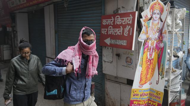 Un habitant de New Delhi marche avec un masque pour se protéger de la pollution [Keystone - Manish Swarup]